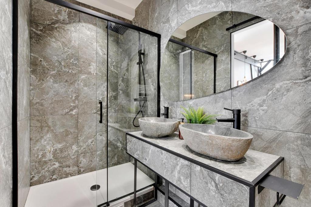 a bathroom with two sinks and a mirror at GemBnB Luxury Apartments - Sedaine in Paris