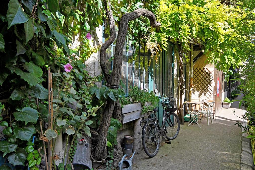 a bike parked next to a wall with plants at GemBnB Luxury Apartments - Sedaine in Paris