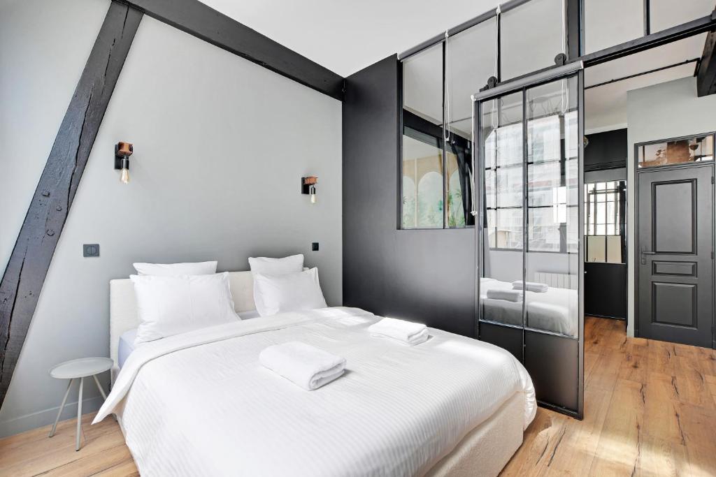a bedroom with a large white bed and a window at GemBnB Luxury Apartments - Sedaine in Paris