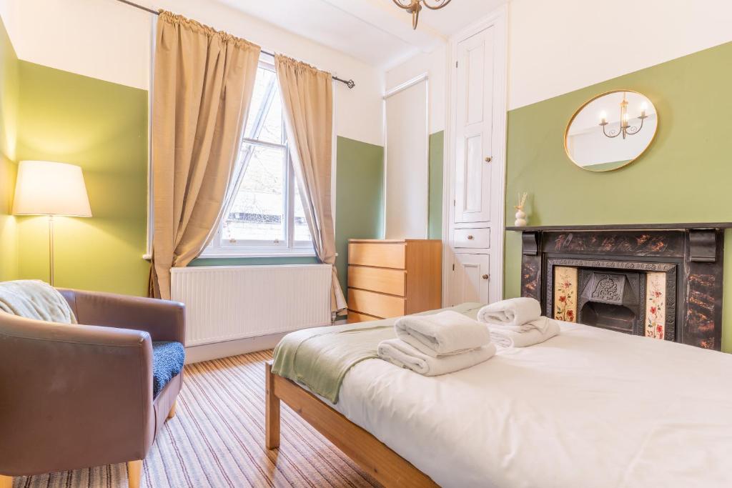 um quarto com uma cama, uma cadeira e uma lareira em Monthly Discounts,10 Guests, Business em Leicester