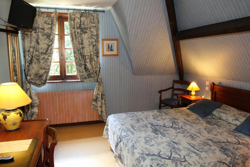 1 dormitorio con cama, escritorio y ventana en Golf Hotel, en Le Tréport