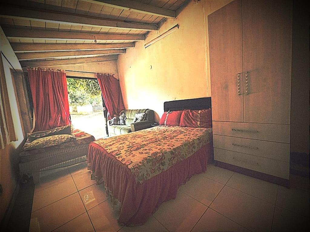 1 dormitorio con 1 cama, vestidor y ventana en Hostal mburucuyá, en Ciudad del Este
