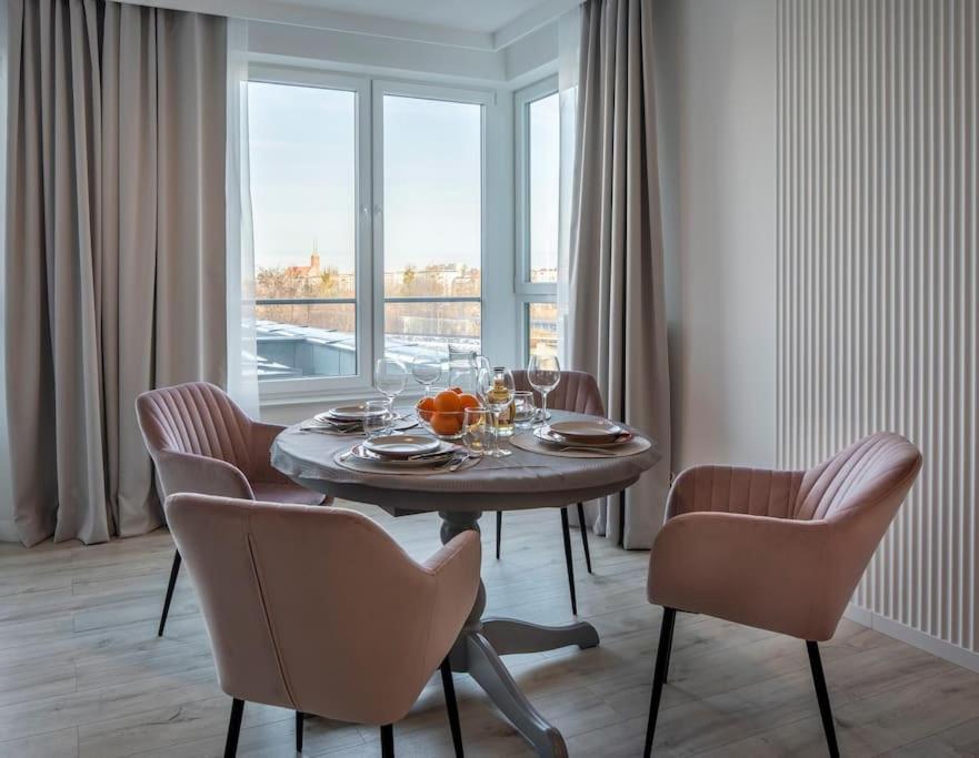 a dining room with a table and chairs and a window at Platinum 1 in Gdynia