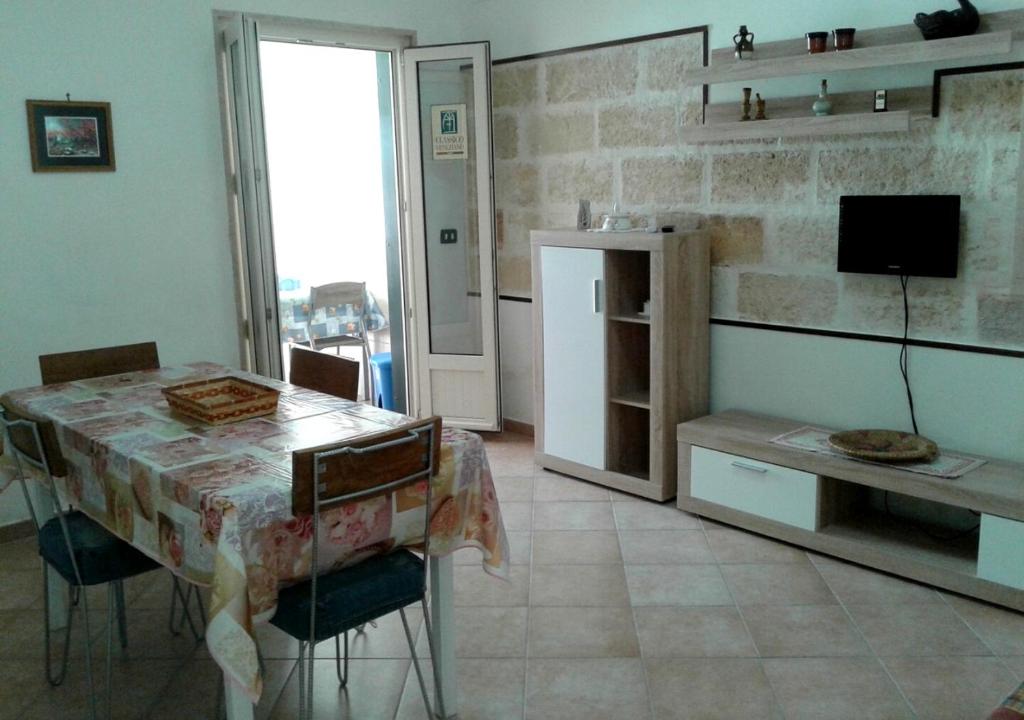 a kitchen with a table with chairs and a television at Casa Giovanni by My Home Apulia in Torre Lapillo