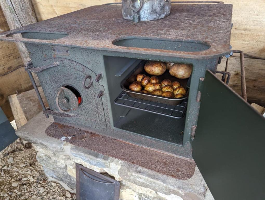 una vieja estufa con una sartén de patatas. en Shires Barns, en Chippenham