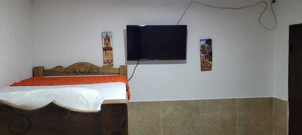 a bedroom with a bed and a flat screen tv on the wall at posada barrios mar in Cartagena de Indias