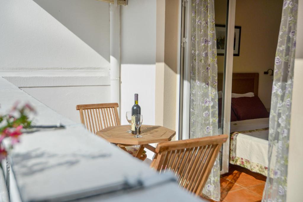 a table with a bottle of wine and two chairs at Hotel Villa Perla Di Mare in Budva
