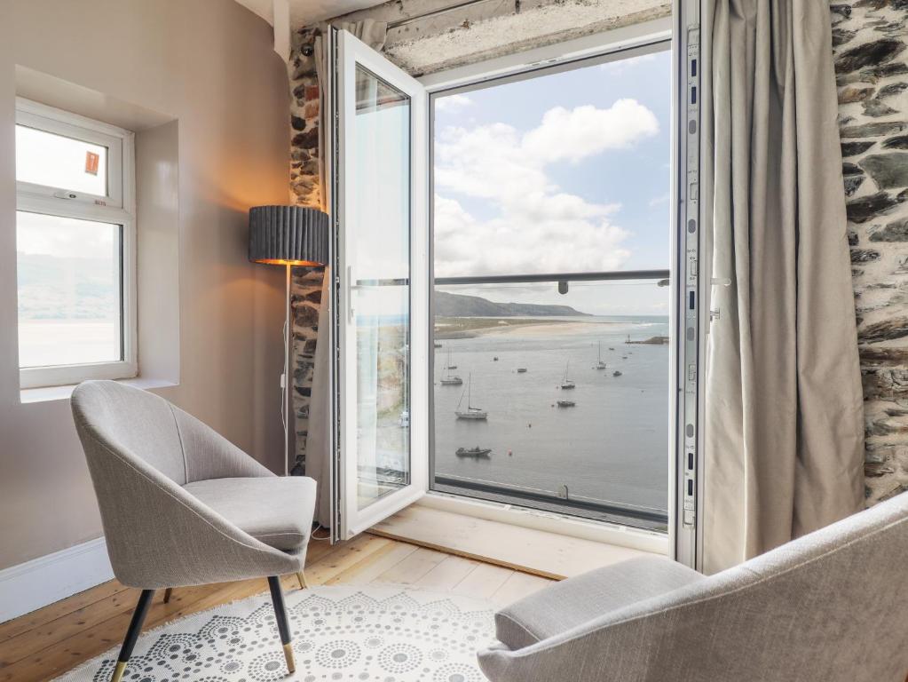 a room with a large window with a view of the ocean at Windycroft in Barmouth