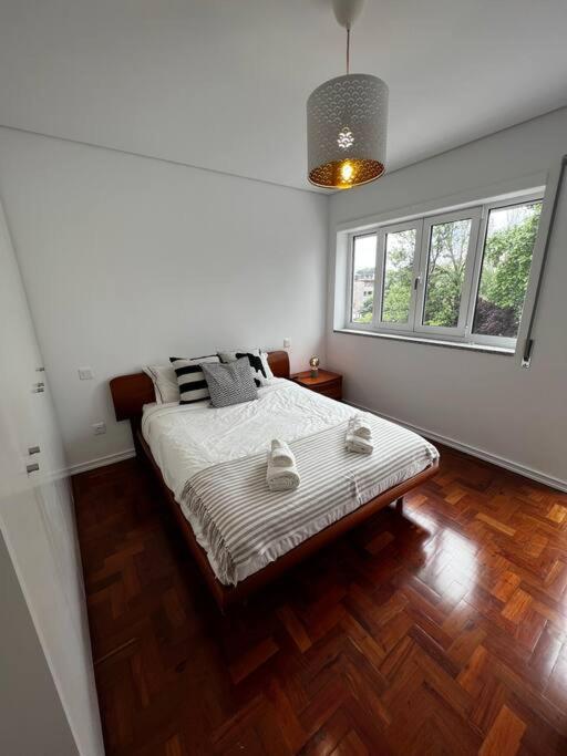 a bedroom with a bed and two windows at Casa da Praça 2 in São João da Madeira