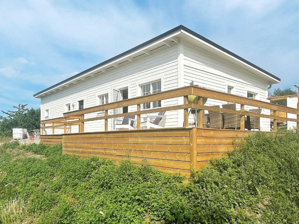 ein weißes Haus mit einer großen Terrasse auf einem Hügel in der Unterkunft Holiday home BORGHOLM XVII in Borgholm