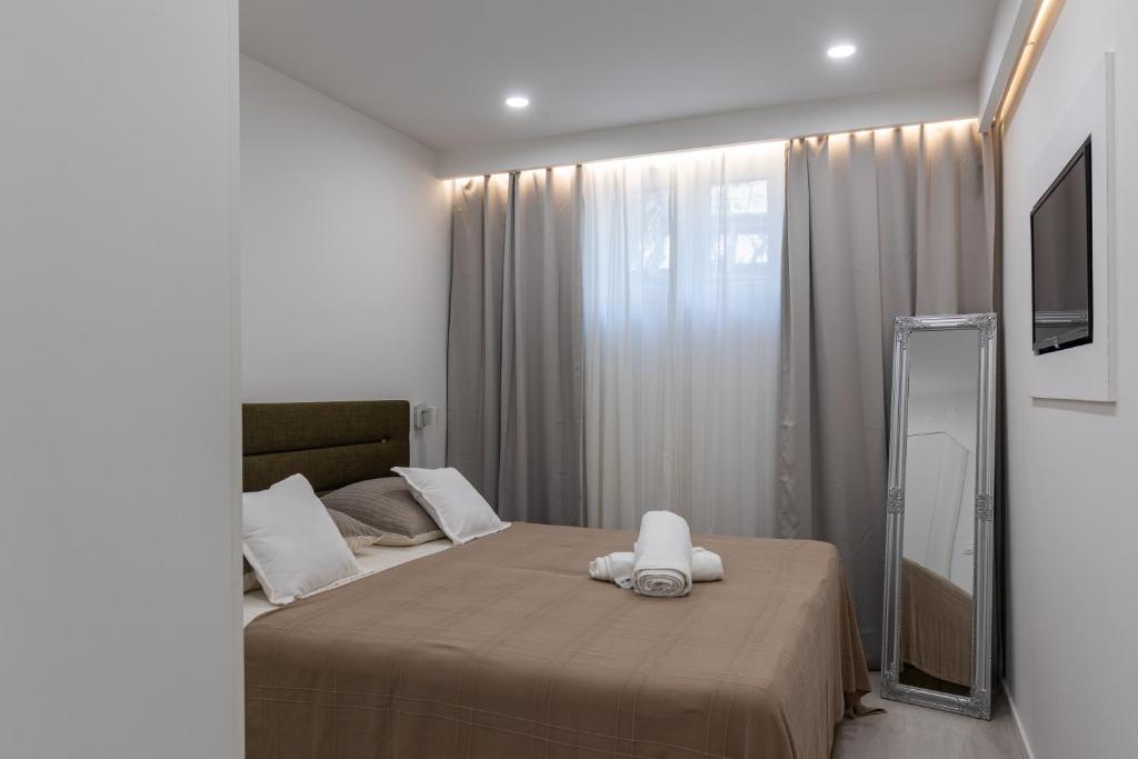 una camera da letto con un letto e un asciugamano sopra di Apartmani Glavinić a Čibača