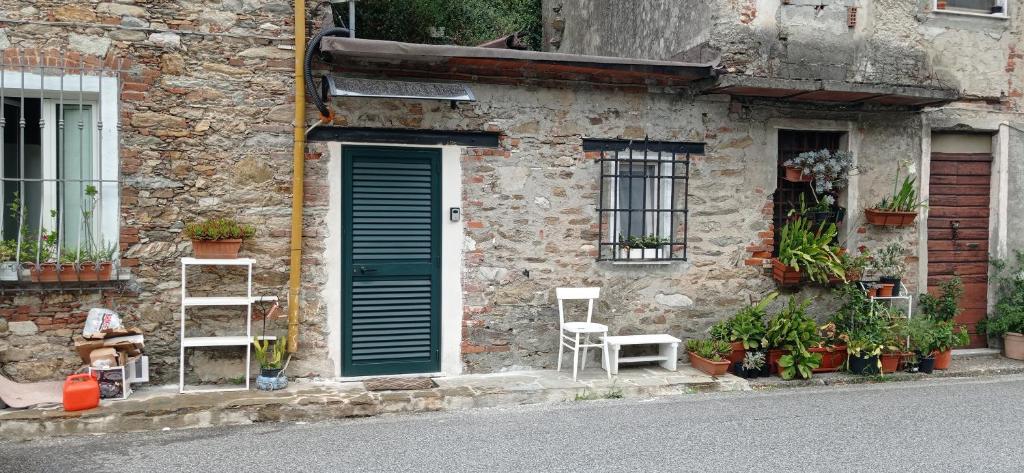 een stenen gebouw met een blauwe deur en enkele planten bij The small waterfall house, la cascatella in Massa
