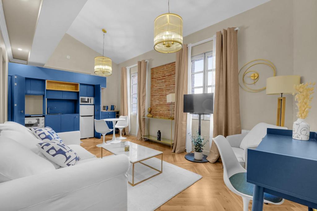 a living room with white furniture and blue walls at Les Relais du Capitole - Appartements d'hôtes in Toulouse