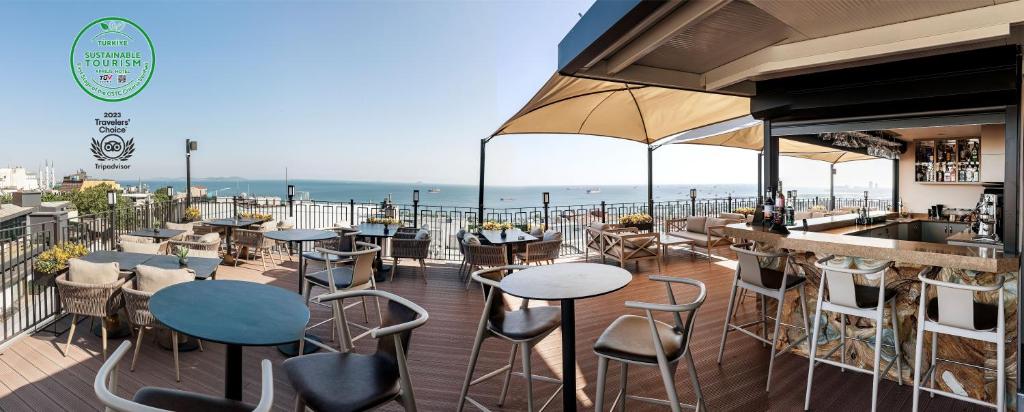 een bar met tafels en stoelen op een balkon met uitzicht op de oceaan bij Aprilis Hotel - Special Category in Istanbul