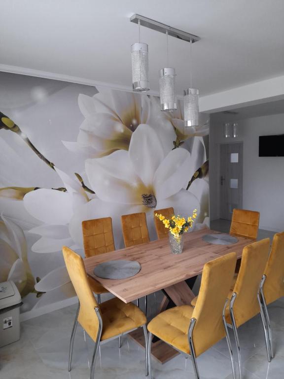 a dining room with a large flower mural on the wall at Apartmany Dianka in Veľký Slavkov
