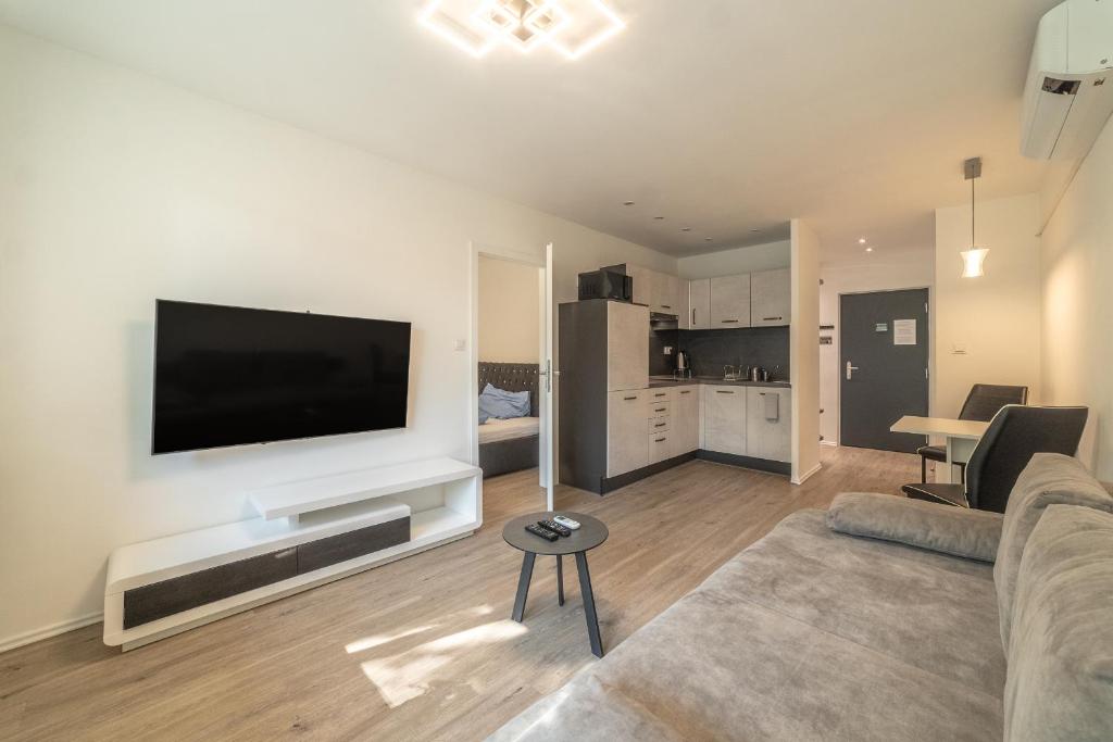 a living room with a couch and a television on a wall at AR Rezidencia Fibichova in Košice