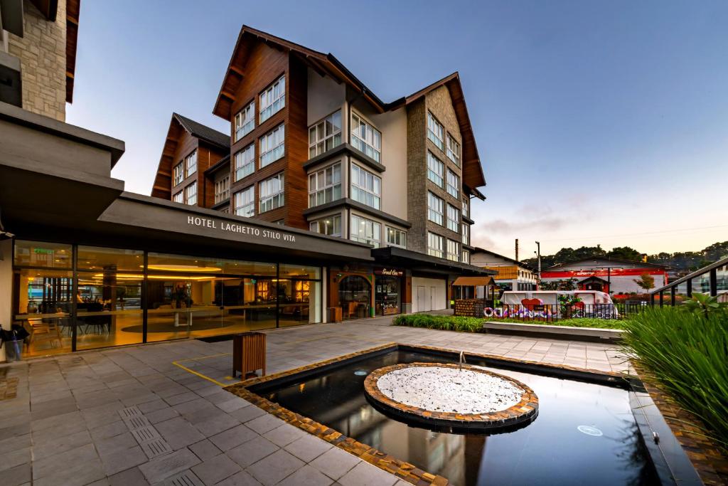 a hotel courtyard with a fountain in front of a building at Laghetto Stilo Vita in Gramado