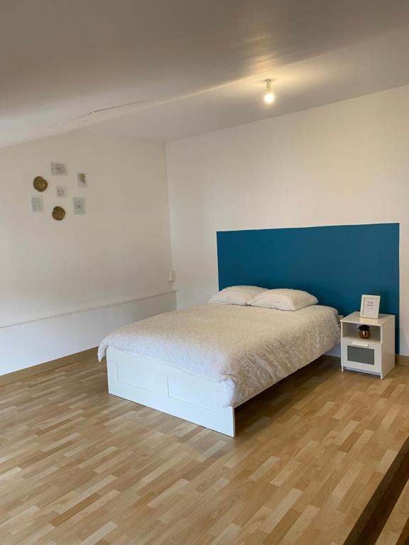 a bedroom with a bed with a blue headboard at Maison Triplex à deux pas du centre ville in Saint-Dizier