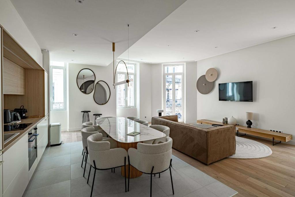 une cuisine et un salon avec une table et des chaises dans l'établissement Superbe appartement 120m2 au coeur de Cannes, à Cannes