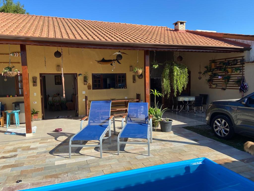 duas cadeiras azuis e uma mesa em frente a uma casa em casa 300 mts da praia em Juqueí