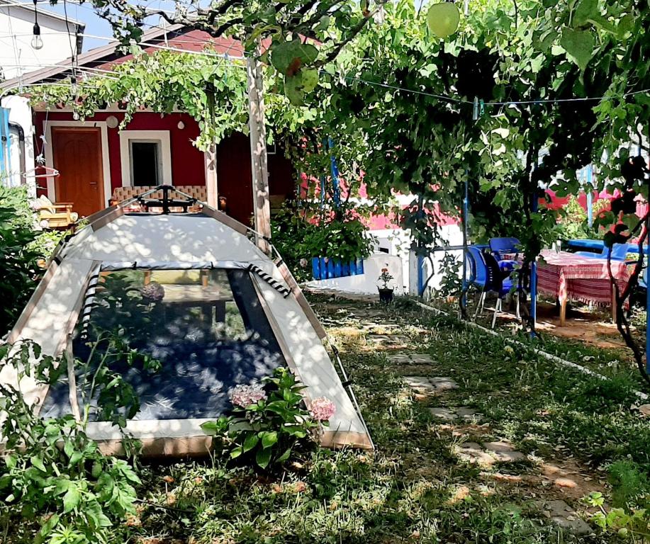 une voiture garée dans la cour d'une maison dans l'établissement Camping SuperPanorama, à Kukës