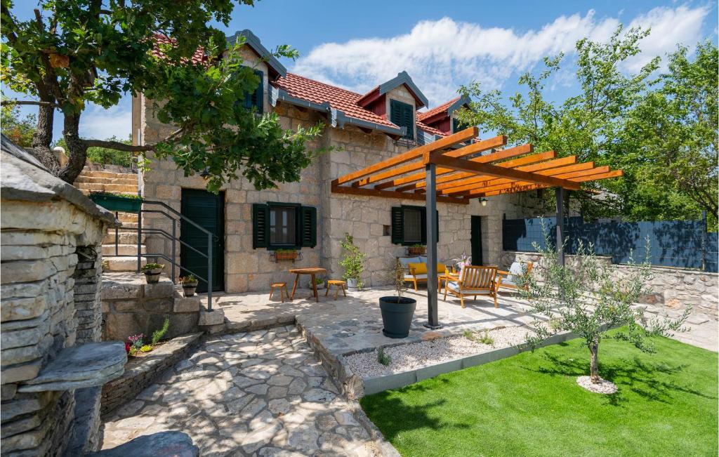 a patio with a wooden pergola in a yard at Awesome Home In Zmijavci With Outdoor Swimming Pool, Wifi And 2 Bedrooms in Zmijavci