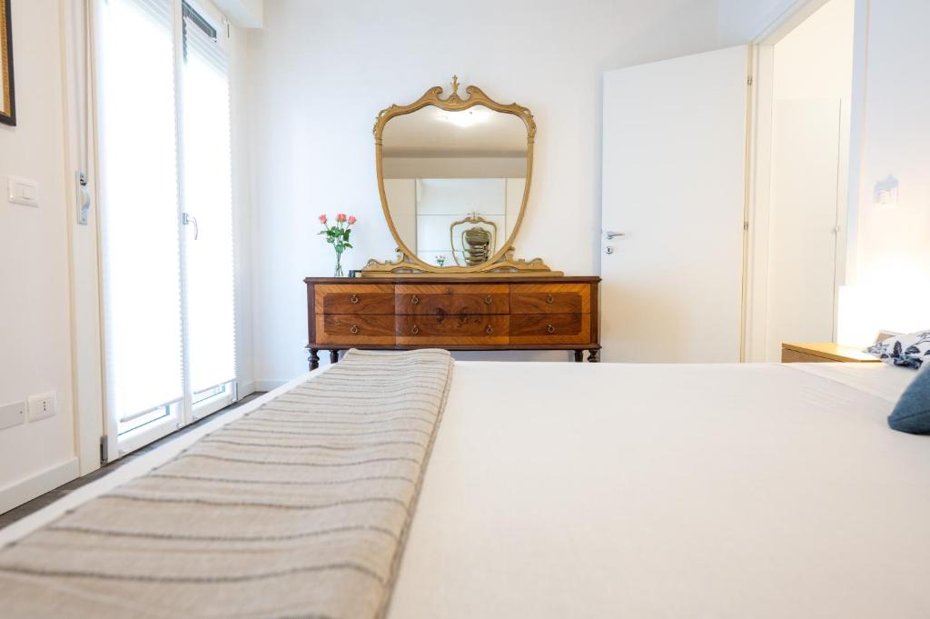 a bedroom with a large bed and a dresser with a mirror at MYHOUSE APARTMENT in Cervignano del Friuli