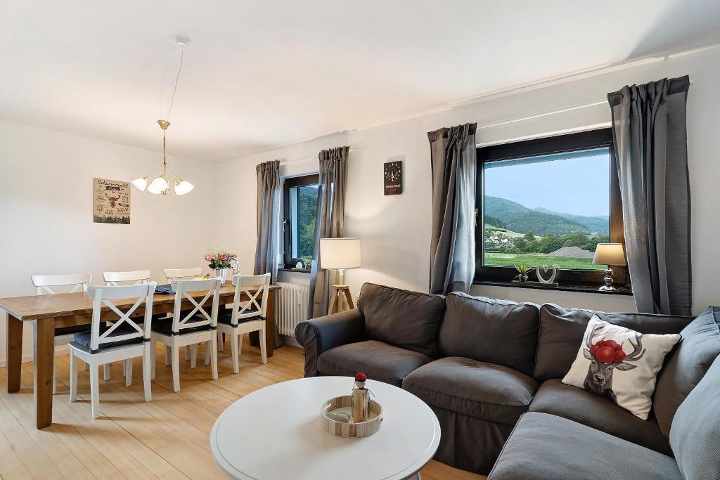uma sala de estar com um sofá e uma mesa em Ferienwohnung Emma em Gutach im Breisgau