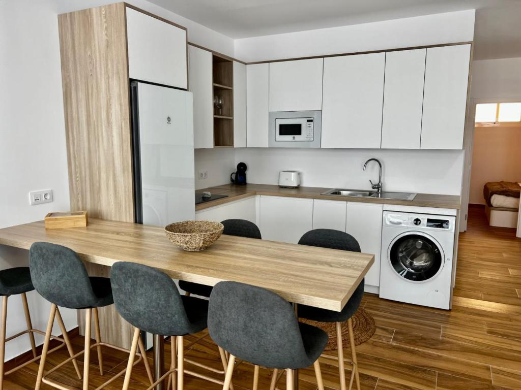 a kitchen with a wooden table and chairs at Amber L5 in Armeñime