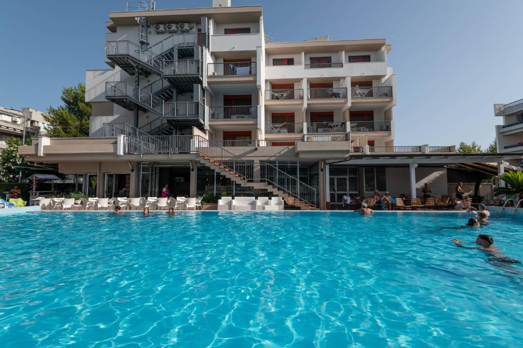 a swimming pool in front of a hotel at Hotel Club La Villa in Martinsicuro