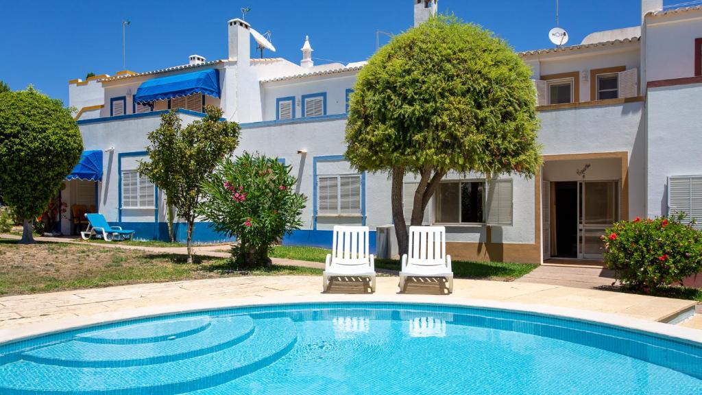 a villa with a swimming pool in front of a house at Casa Mia by LovelyStay in Lagoa