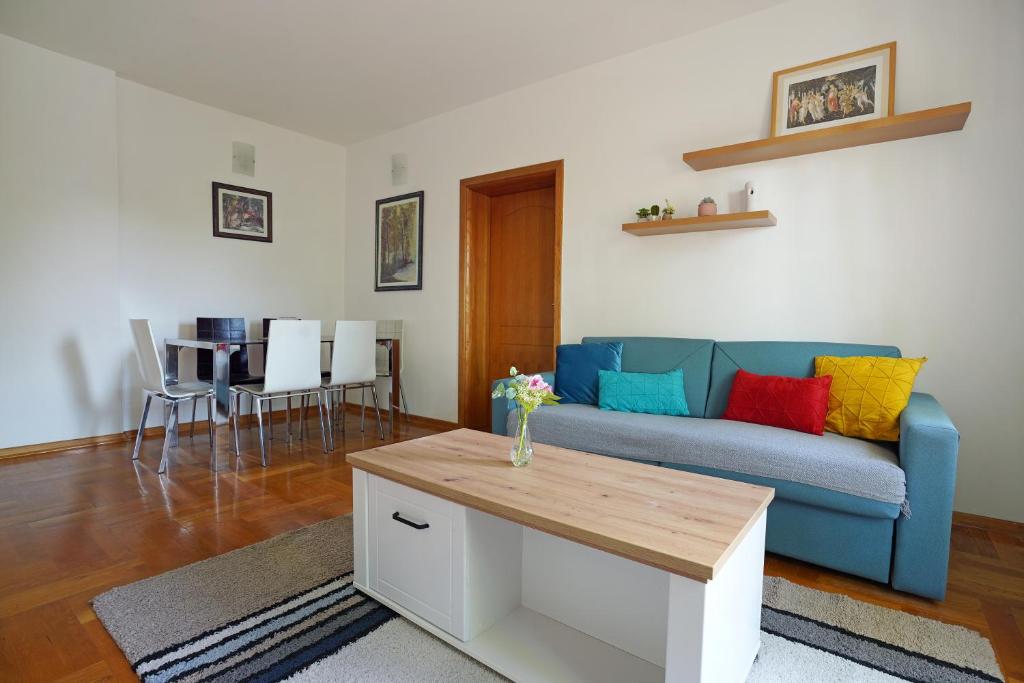 uma sala de estar com um sofá azul com almofadas coloridas em Apartment GOLD em Podgorica