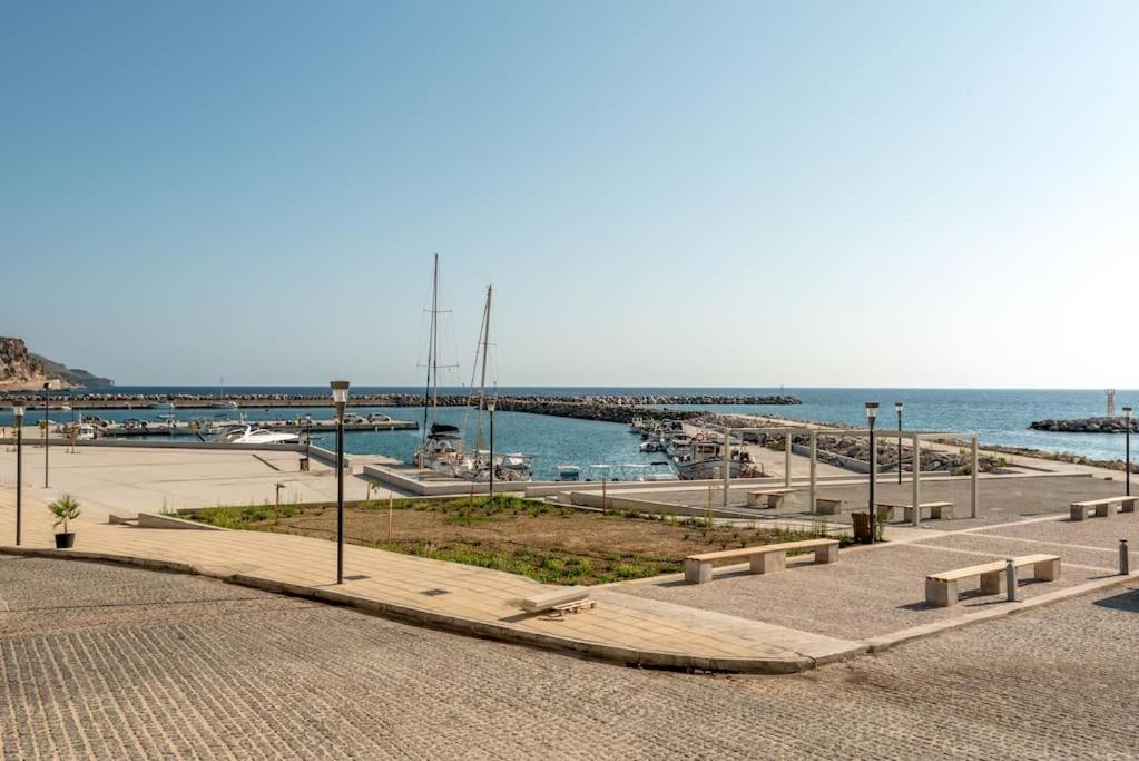 a park with benches and a pier next to the water at SeãCret in Kolymvari