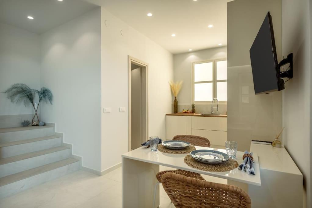 a dining room with a table with chairs and a television at SeãCret in Kolymvari