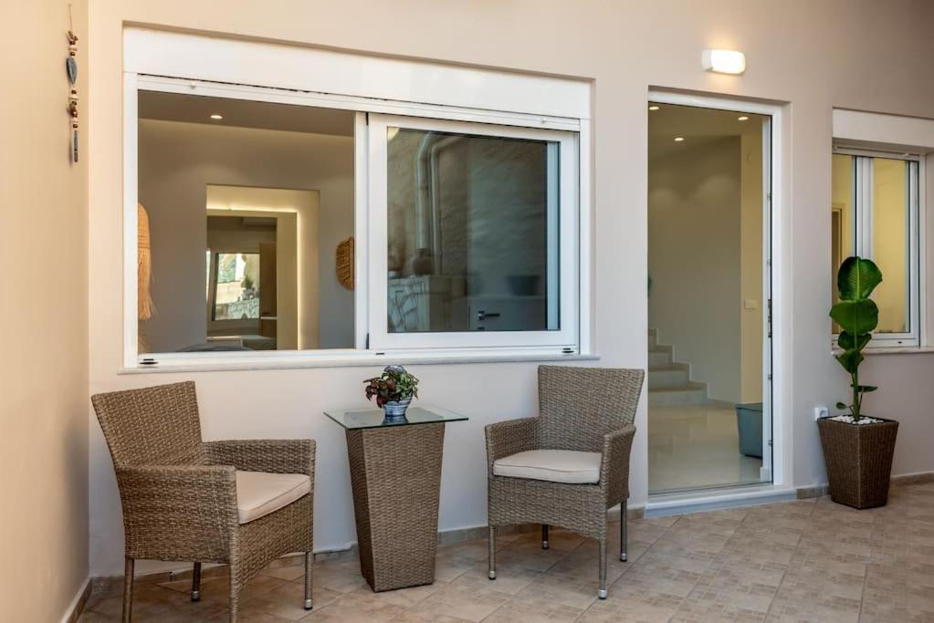 a patio with chairs and a table and a window at SeãCret in Kolymvari