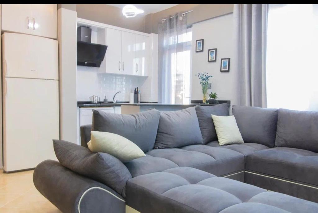 Il comprend un salon avec un canapé et une cuisine. dans l'établissement Modern cozy beach apartment, à Payallar