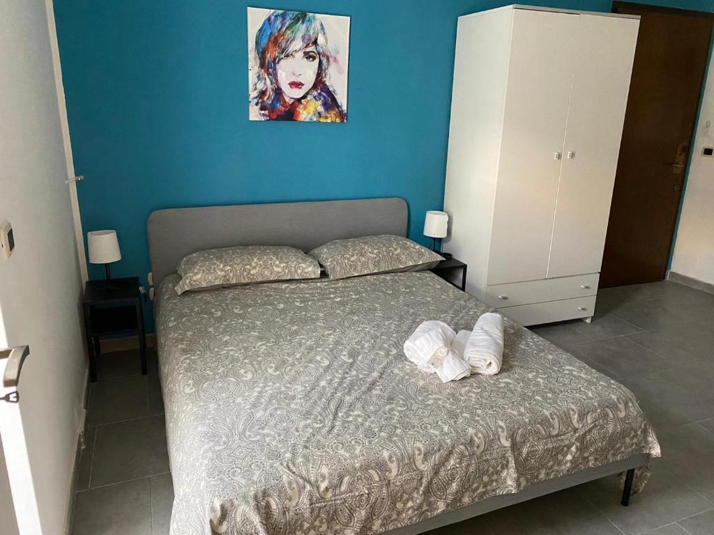 una camera da letto con un letto e un dipinto sul muro di HOLIDAY PATRIZIA'S HOME a San Giorgio Ionico