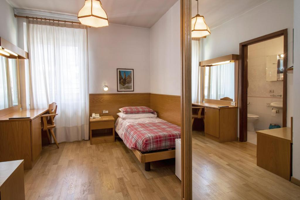 Postel nebo postele na pokoji v ubytování Hotel Pinzolo-Dolomiti