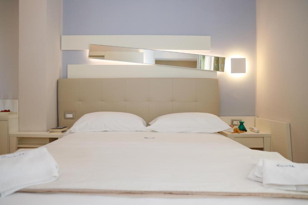 1 dormitorio con 1 cama blanca y 2 almohadas en Agave Blu, en San Nicolò