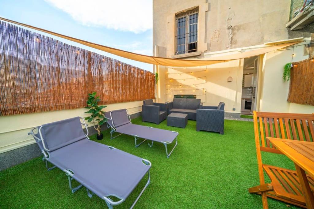 a patio with chairs and tables on the grass at Le Moka II et sa terrasse Cosy in Fontaine