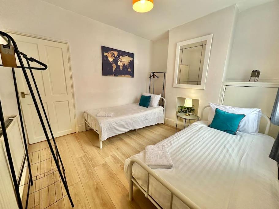 a small room with two beds and a mirror at EasyRest House 3 Grantham - 5 Beds & Free Parking - Easy Location - Access to A1, Town Centre & Shops in Grantham