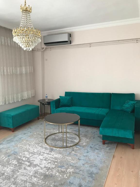 ein Wohnzimmer mit einem grünen Sofa und einem Tisch in der Unterkunft Vintage Square apartment in Zeytinburnu in Istanbul