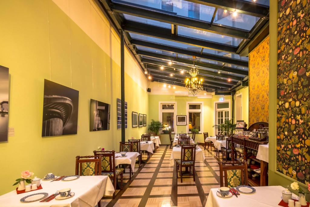 a restaurant with tables and chairs in a room at Myer's Hotel Berlin in Berlin