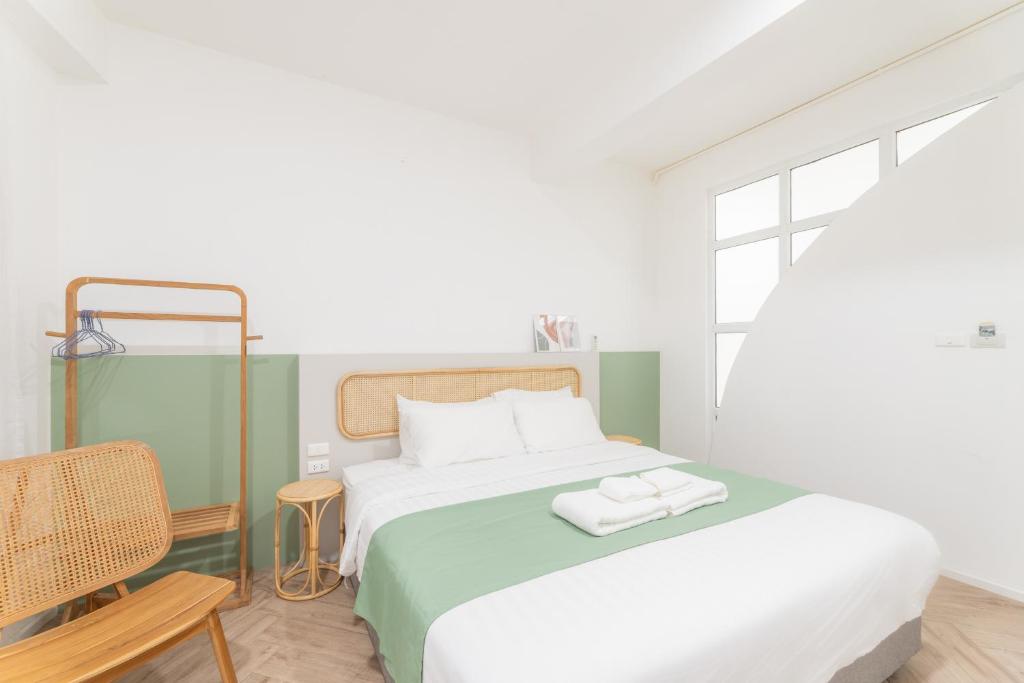 1 dormitorio con 1 cama con 2 toallas en Evergreen apartment by Beginning with, 3BR in heart of Nimman, en Chiang Mai