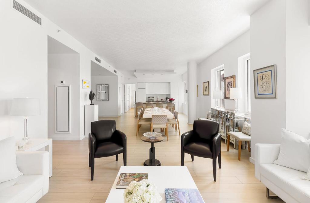 - un salon avec des chaises noires et un canapé blanc dans l'établissement Luxury Midtown West 4 Bedroom Apartment Near Radio City, à New York