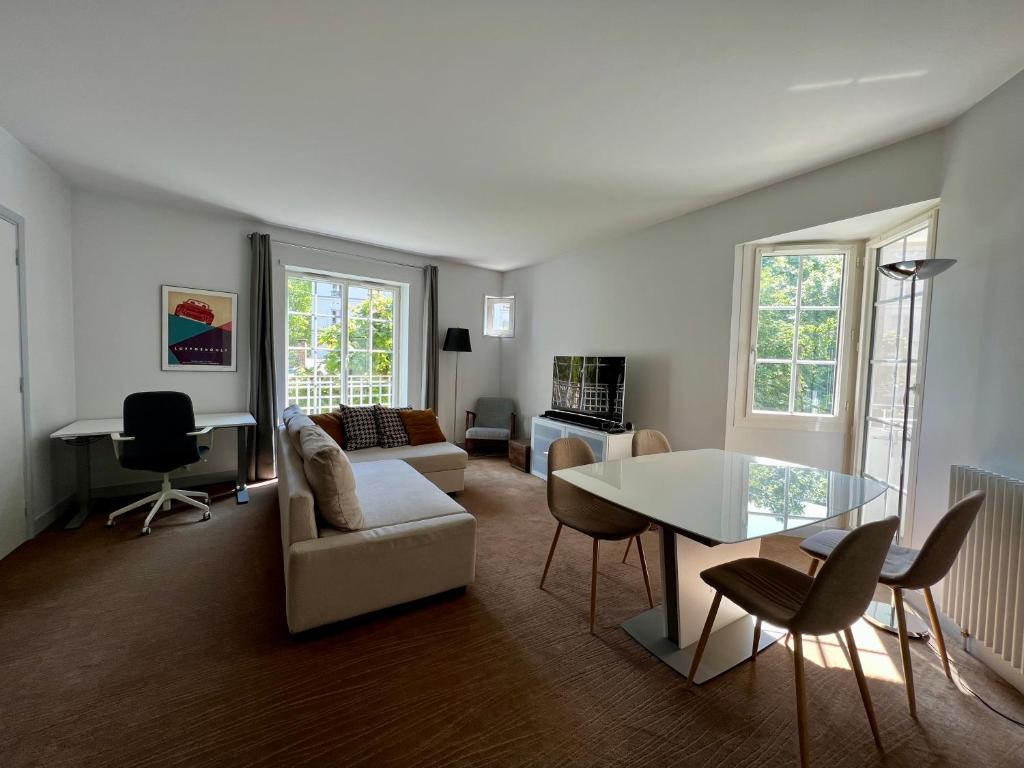 ein Wohnzimmer mit einem Sofa und einem Tisch in der Unterkunft Spacious & modern flat close to Parc Monceau in Paris