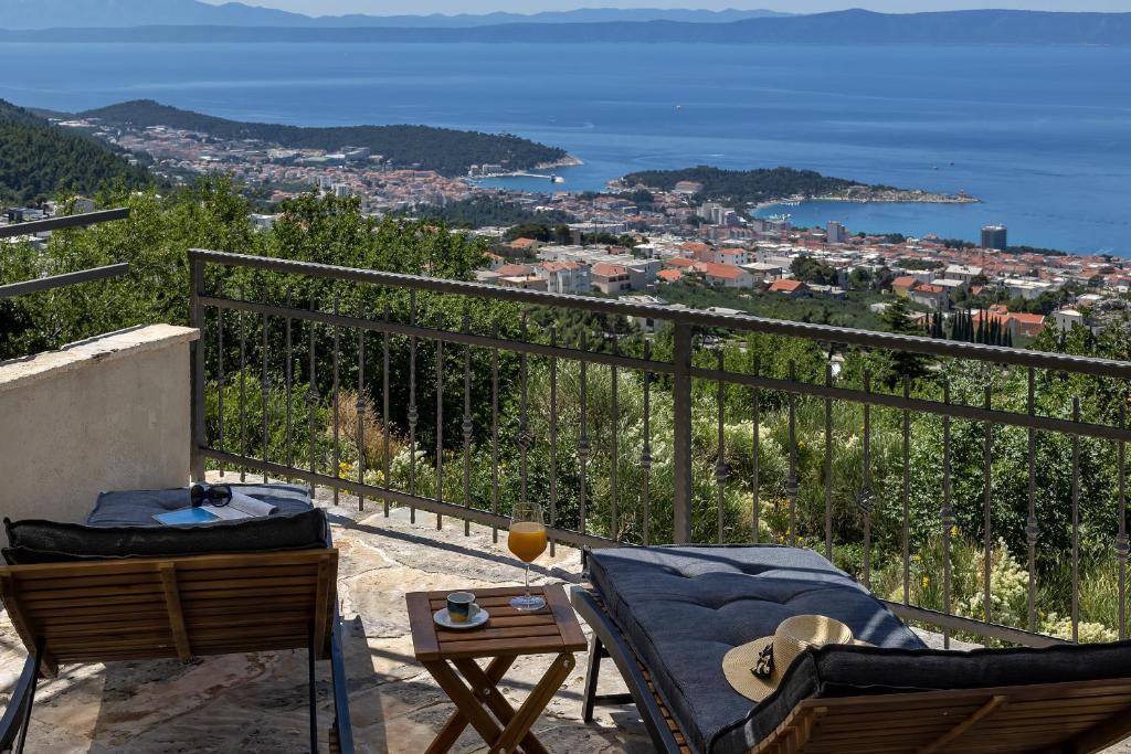 a balcony with chairs and a view of the ocean at Cottage Baskovic in nature park in Makarska
