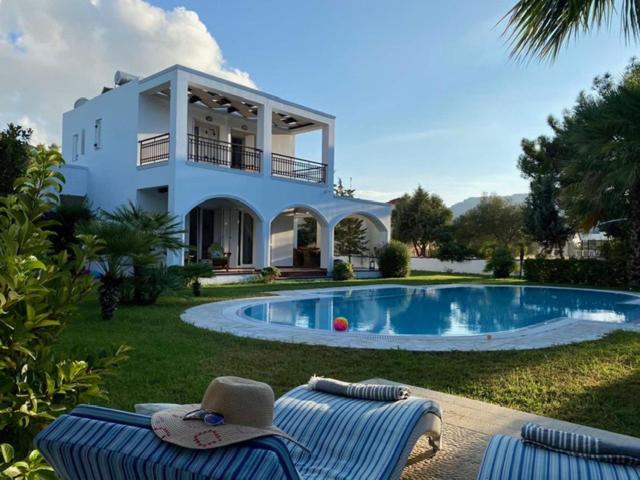 ein Haus mit einem Pool vor einem Haus in der Unterkunft Villa Sofia with garden, pool and lounge areas in Kolymbia