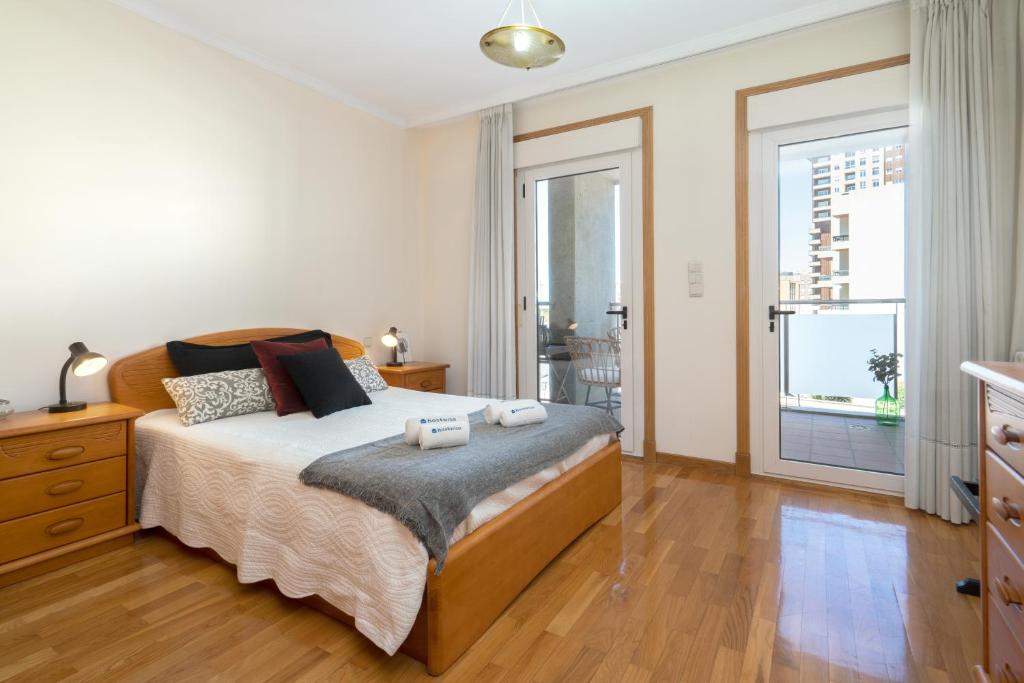 een slaapkamer met een bed met twee handdoeken erop bij Homely Fresh Apartment - Terrace & Garage in Póvoa de Varzim