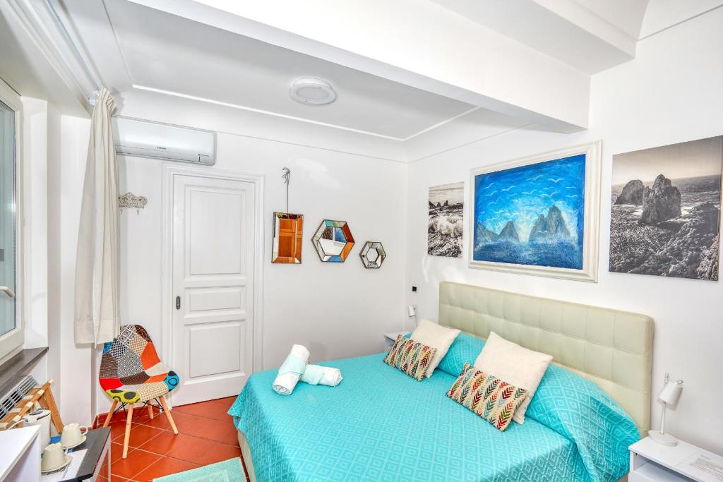 a bedroom with a blue bed and a chair at Acquaviva 31 in Capri